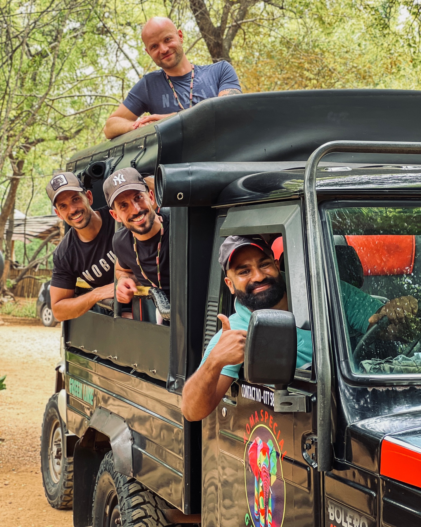 Happy tourists with driver in safari jeep